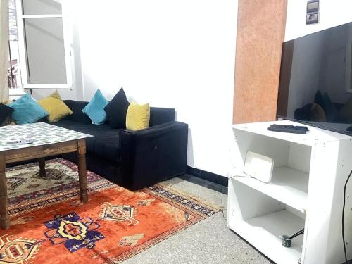 a living room with a black couch and a table at Agdal apart in Rabat