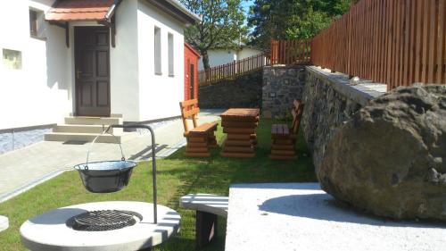 a grill in the yard of a house with a rock at Macskakő Vendégház in Somoskőújfalu