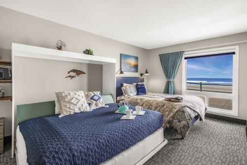 a bedroom with a bed and a view of the ocean at Oceanfront Studio - Ground Floor - Sleeps 4 in Lincoln City
