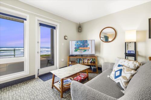 una sala de estar con un sofá y una mesa en Oceanfront Studio - Ground Floor - Sleeps 4, en Lincoln City
