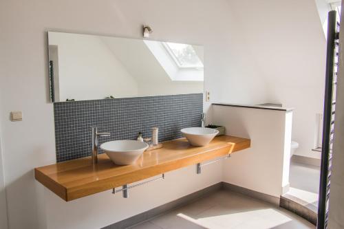 a bathroom with two sinks on a wooden counter at Green& Light House16 in Kettenis