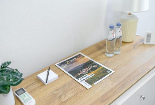 APARTAMENTY z GÓRSKIM KLIMATEM في دوشنيكي زدروي: طاولة عليها مجلة وزجاجة ماء
