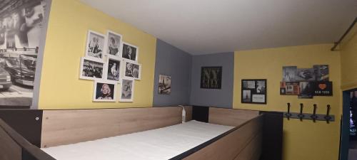 a bedroom with a bed with pictures on the wall at Lit en dortoir pour homme chez l'habitant au Kremlin-Bicêtre in Le Kremlin-Bicêtre