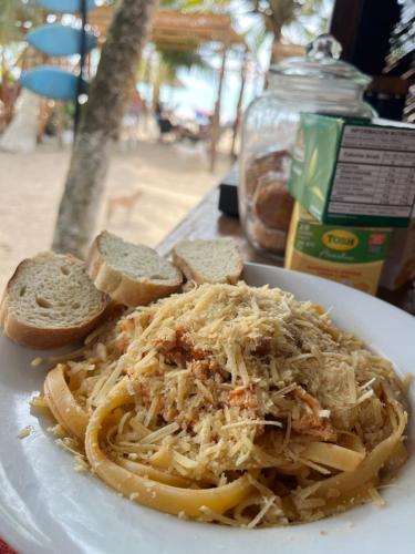 a plate of pasta with cheese and bread on a table at Aquarius Diving Club y Cabañas in Rincón