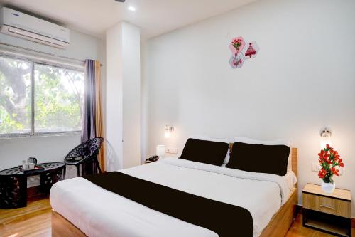 a bedroom with a large bed and a window at Super Townhouse Lalmati National Highway 27 Formerly The Pinnacle Inn in Dispur