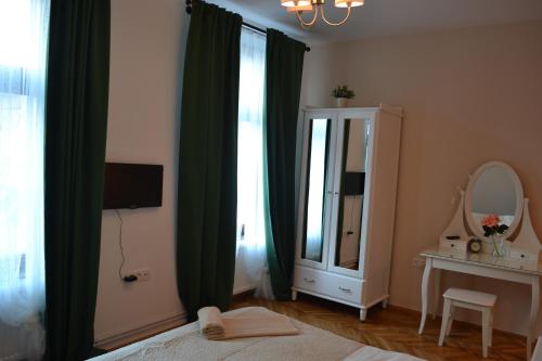 a bedroom with green curtains and a mirror and a bed at Casa Krone - Piața Sfatului in Braşov