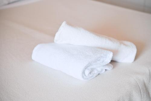 a pile of white towels sitting on a bed at Charme Hotel La Villa Tina in Ischia