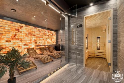 a lobby with chairs and a brick wall at Apartments M&M, GRATIS parking, basen, sauna, siłownia in Kołobrzeg