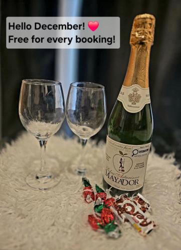 a bottle of champagne and two wine glasses on a table at Cozy Boho Room at the Heart of Vancouver! Private Parking, Self Check-in & just 4 mins to Metrotown! in Burnaby
