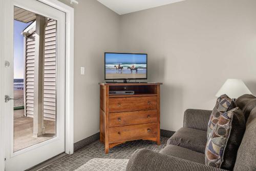 a living room with a television on a wooden dresser at Pool and Hot Tub Ground Floor Studio - Oceanfront - Full Kitchen - Patio in Lincoln City