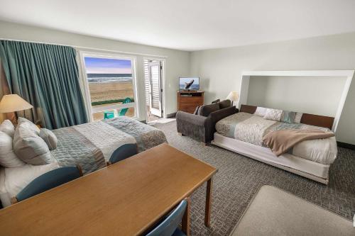 a hotel room with a bedroom with a bed and a table at Pool and Hot Tub Ground Floor Studio - Oceanfront - Full Kitchen - Patio in Lincoln City