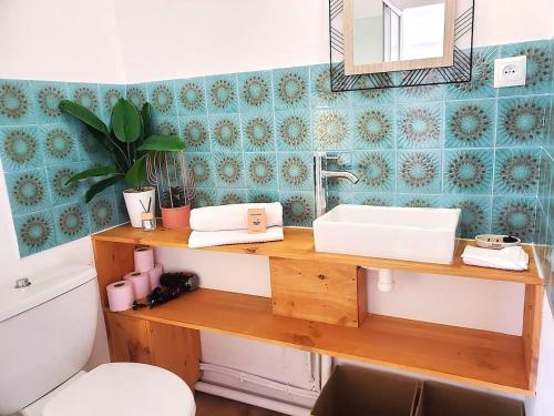 a bathroom with a sink and a toilet and a mirror at Au Bord De L'eau, Proche plages in Saint-Jean-de-Monts