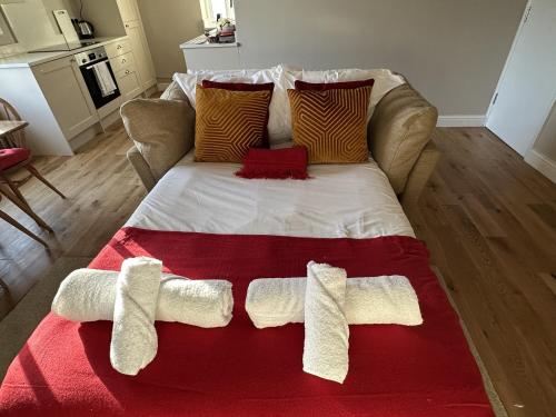 a large bed with two white towels on it at Queens Terrace Apartments in Exeter