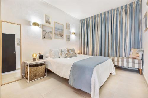 a hotel room with a bed and a tv at Manelinha Apartment - cozy apartment with pool and beach in Quarteira