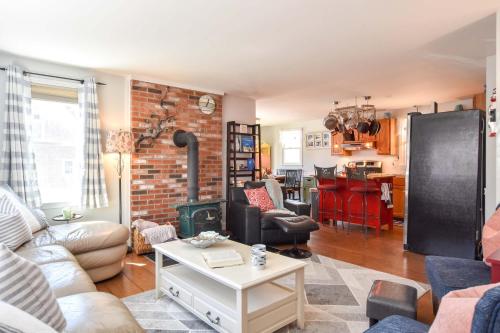 ein Wohnzimmer mit Kamin und Ziegelwand in der Unterkunft 5 Min to Beach Yard w Fire Pit in Wellfleet