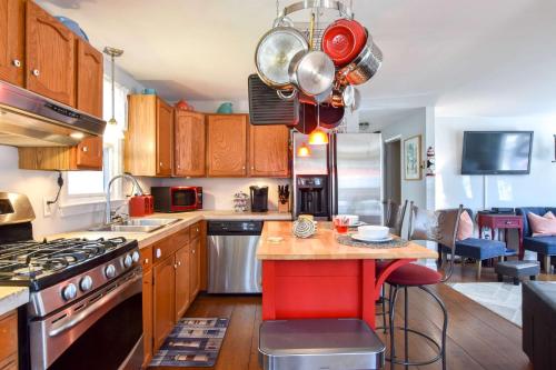 a kitchen with wooden cabinets and a red island at 5 Min to Beach Yard w Fire Pit in Wellfleet
