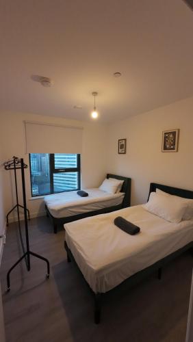 a room with two beds and a window at Modern 2BR Wembley Apartment Stadium Views and Balcony in London