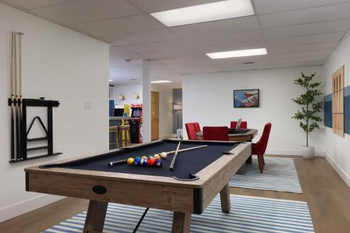Pine & Paddle Getaway Game Room Hot Tub Pool في مسكيغون: غرفة معيشة مع طاولة بلياردو في غرفة