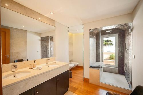 a bathroom with two sinks and a glass shower at Bafureira 22 Rooftop in Parede