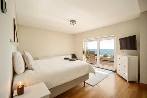 a bedroom with a large bed and a large window at Bafureira 22 Rooftop in Parede
