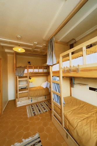 a room with three bunk beds in it at Muza Guest House in Tamraght Ouzdar