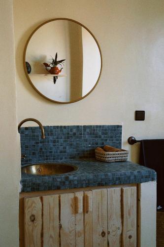 a bathroom with a sink and a mirror at Muza Guest House in Tamraght Ouzdar