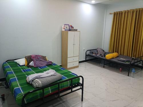 Airstay hotel and restaurant في بنوم بنه: غرفة نوم بسرير وسرير وكابينة