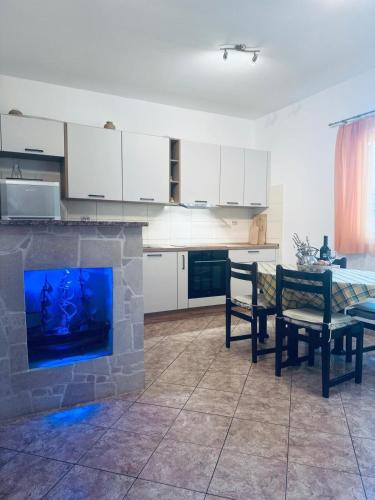 a kitchen with a fireplace with a table and chairs at Apartment Deni in Milna