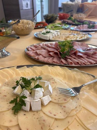 une table recouverte de assiettes de nourriture avec de la viande et du fromage dans l'établissement Pastoral Lodge at the Sanctuary of the Divine Mercy, à Cracovie