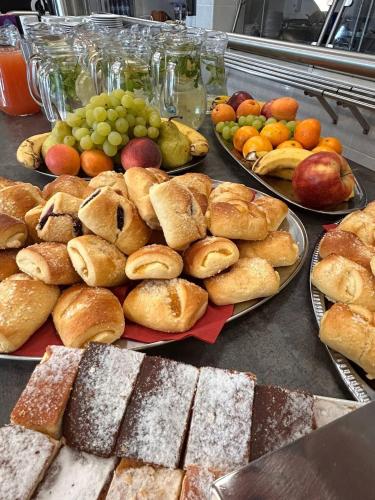 une table recouverte de assiettes de pâtisseries et de fruits dans l'établissement Pastoral Lodge at the Sanctuary of the Divine Mercy, à Cracovie