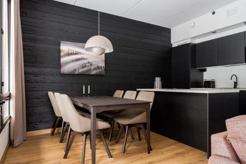a kitchen and dining room with a table and chairs at Le Chalet Lingonberry D14 Ski-in Ski-out by Aavalevi in Levi