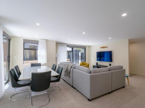 a living room with a couch and a table at Architectural Retreat in Prestigious Whanganui in Whanganui