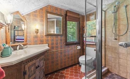 een badkamer met een toilet, een wastafel en een douche bij Smugglers Trove in Morses Mill