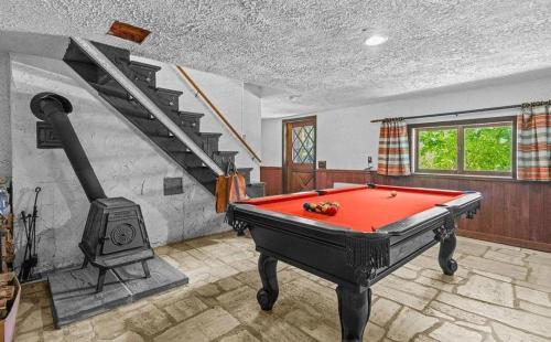 a room with a pool table and a staircase at Smugglers Trove in Cambridge