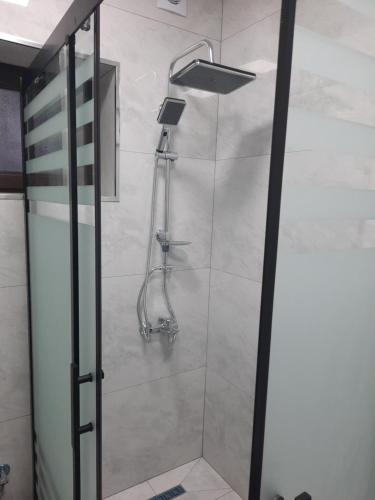 una ducha en un baño con puerta de cristal en Уютный дом для семьи AL INN, en Qusar