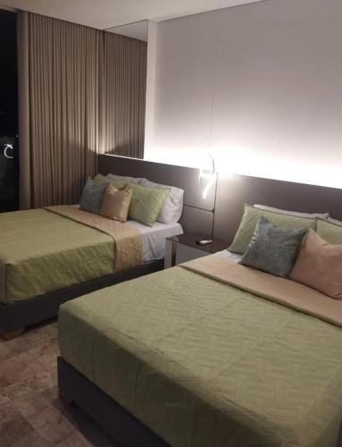 Una habitación de hotel con dos camas y una lámpara. en Brand New Modern Apartment-Suite Meters from the Beach, en Gaira