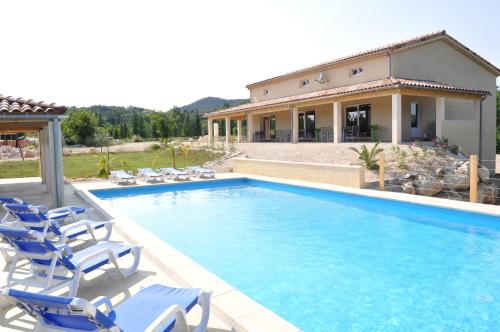 - une piscine avec des chaises et une maison dans l'établissement Villa Vallon Pont d'Arc, à Vallon-Pont-dʼArc