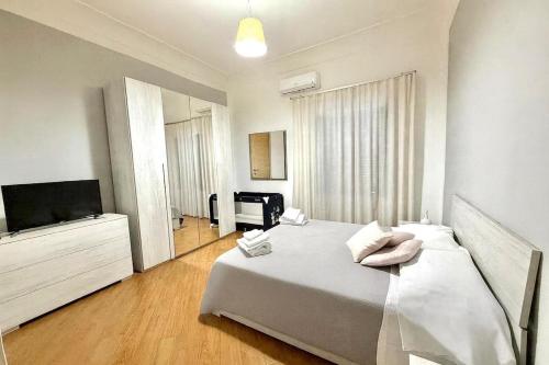 una camera da letto con un letto e una TV a schermo piatto di House by the station -Close to Oplonti Ruins a Torre Annunziata