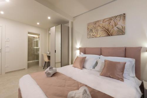 a bedroom with a large bed with white and brown pillows at B&B IL MORO Boutique Rooms in Siena