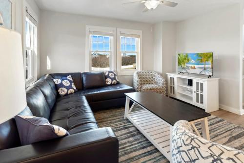 Una sala de estar con un sofá de cuero negro y una mesa. en CAC-17B - Scallop, en Buxton