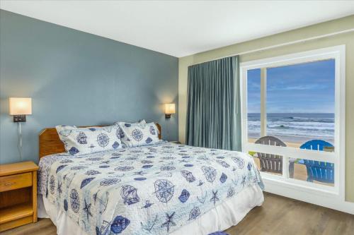 a bedroom with a bed and a view of the ocean at Oceanfront Studio - Ground Floor - King Bed - Easy Beach Access - Pool & Hot Tub in Lincoln City