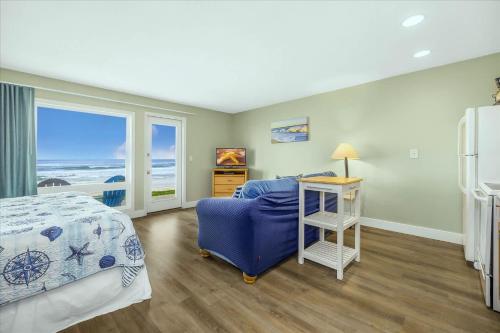 a bedroom with a bed and a desk and a bed and a window at Oceanfront Studio - Ground Floor - King Bed - Easy Beach Access - Pool & Hot Tub in Lincoln City