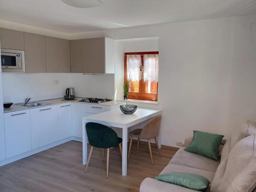 a white kitchen with a table and a couch at Villa Primula in Molveno