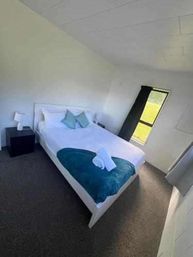 a bedroom with a large white bed with towels on it at Coopers Haven- Beachfront House in Coopers Beach