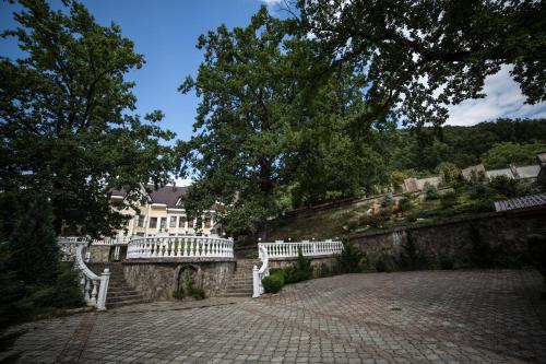 two white benches sitting on top of a stone wall at Gnizdo Golubky in Shaian
