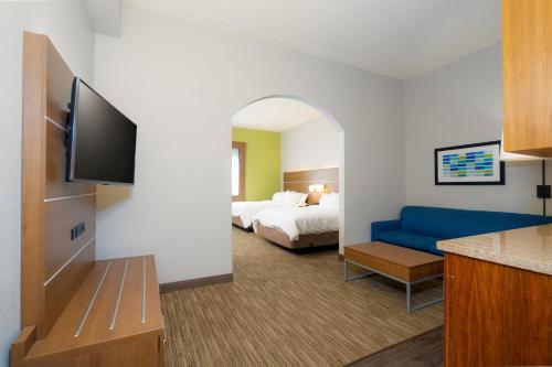 a hotel room with a bed and a blue couch at Holiday Inn Express Hotel & Suites Mankato East by IHG in Mankato