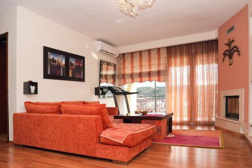 a living room with a orange couch and a table at Central Grevena Retreat with Mountain Views in Grevena