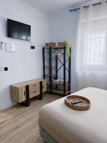 a room with a bed and a table and a tv at Hostal La Casa Del Escudo in Trujillo