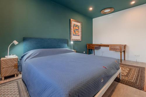 a bedroom with a blue bed and a desk at The Coolest Place near the airport! in Lisbon