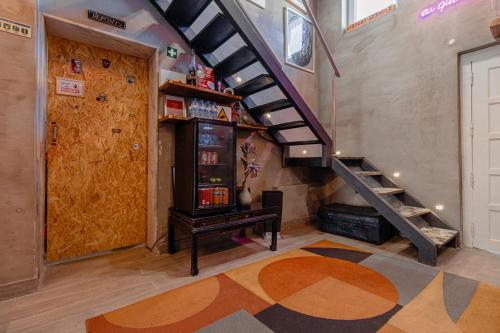 a room with a staircase and a refrigerator and a door at The Coolest Place near the airport! in Lisbon